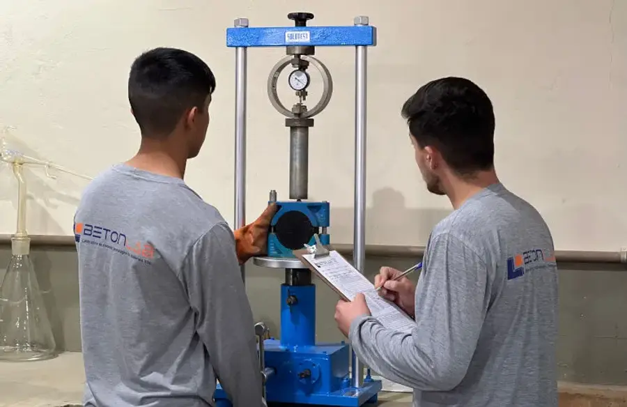 Equipe técnica da BetonLab operando a prensa de compressão